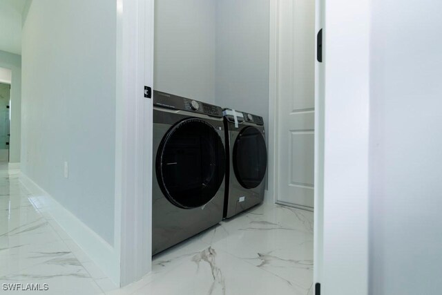 washroom featuring independent washer and dryer, marble finish floors, and baseboards