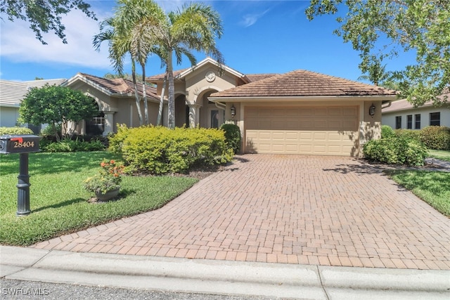 28404 Via Odanti Dr, Bonita Springs, FL 34135 - view of front of property featuring a tile roof, a front yard, a garage, decorative driveway, and stucco siding