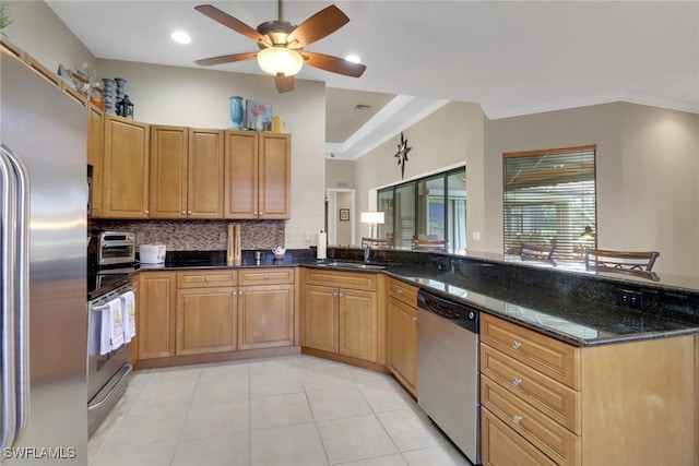28404 Via Odanti Dr, Bonita Springs, FL 34135 - kitchen with a sink, a ceiling fan, dark stone countertops, appliances with stainless steel finishes, and backsplash