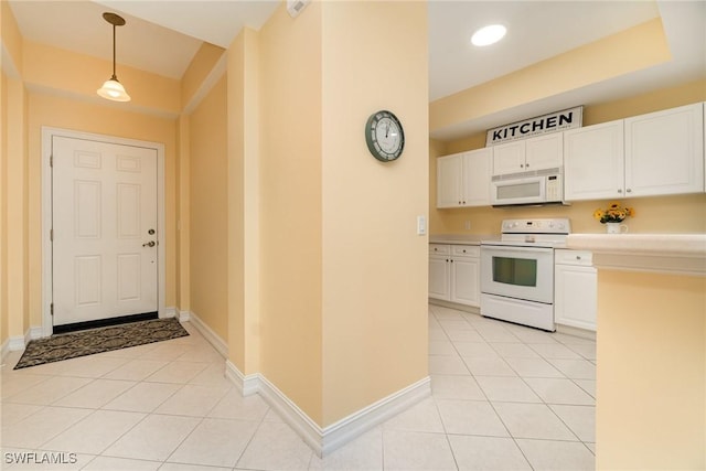 kitchen with decorative light fixtures, light tile patterned floors, white cabinets, and white appliances