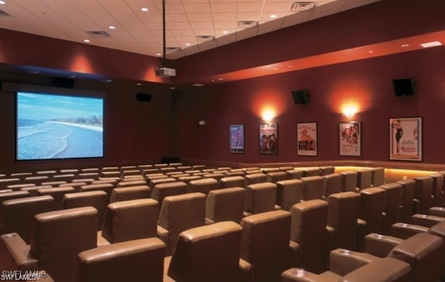 home theater room featuring visible vents, a paneled ceiling, and a wainscoted wall