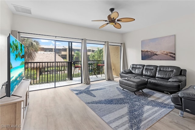living room with visible vents, a ceiling fan, and wood finished floors