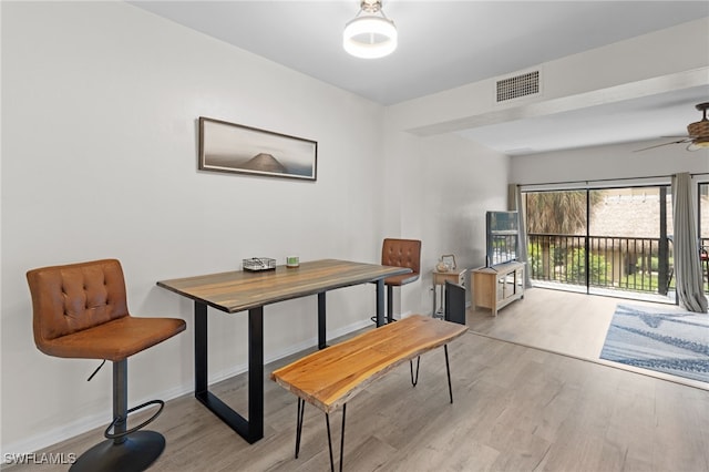 dining room featuring baseboards, ceiling fan, wood finished floors, and visible vents