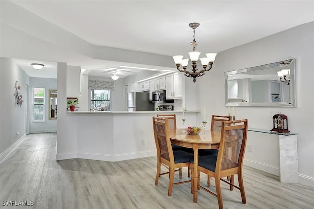 dining room featuring baseboards, ceiling fan with notable chandelier, and light wood-type flooring
