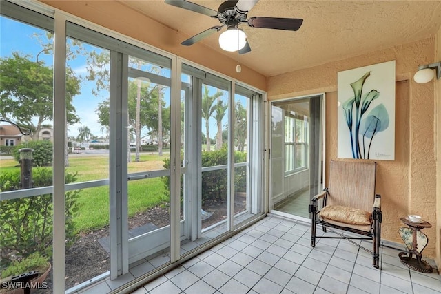 sunroom / solarium featuring a ceiling fan