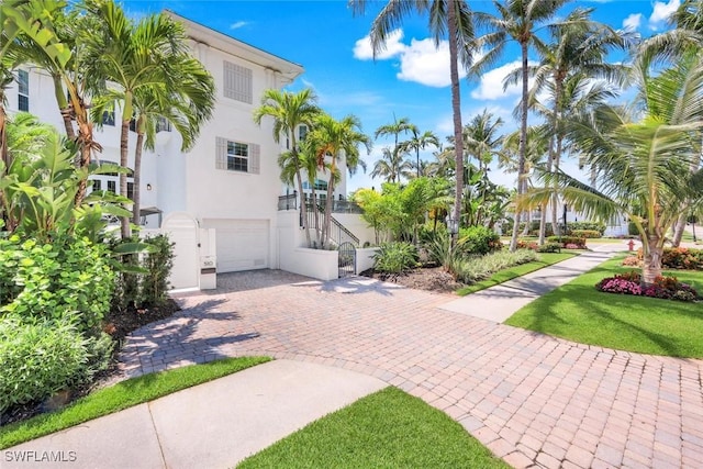 510 2nd St S Unit 102, Naples, FL 34102 - view of front of house with stucco siding, an attached garage, and decorative driveway