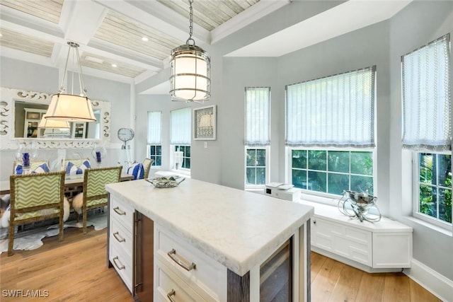 510 2nd St S Unit 102, Naples, FL 34102 - kitchen with white cabinetry, light wood-type flooring, hanging light fixtures, light countertops, and beam ceiling