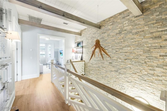 510 2nd St S Unit 102, Naples, FL 34102 - hall with light wood-type flooring, beamed ceiling, baseboards, and an upstairs landing