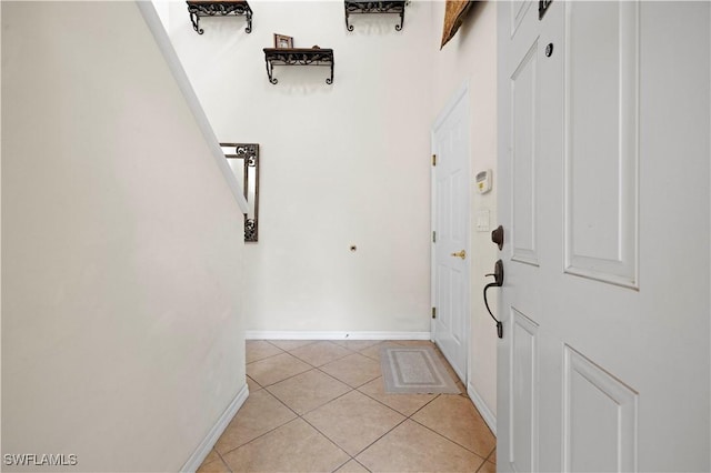foyer with baseboards and light tile patterned flooring
