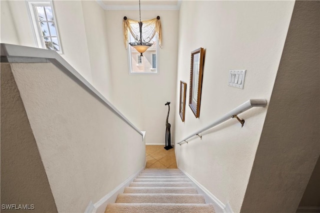 stairway with tile patterned floors, ornamental molding, and baseboards