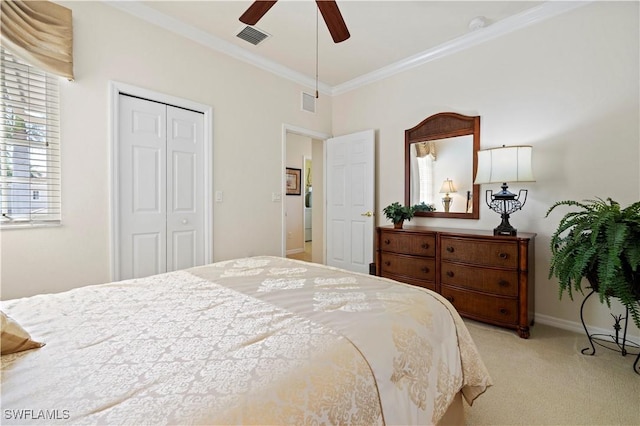 carpeted bedroom with baseboards, visible vents, ornamental molding, and a closet