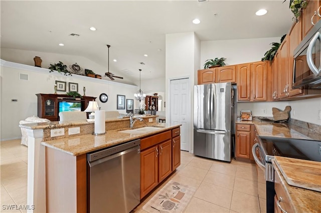 kitchen with stainless steel appliances, light tile patterned floors, an island with sink, and a sink