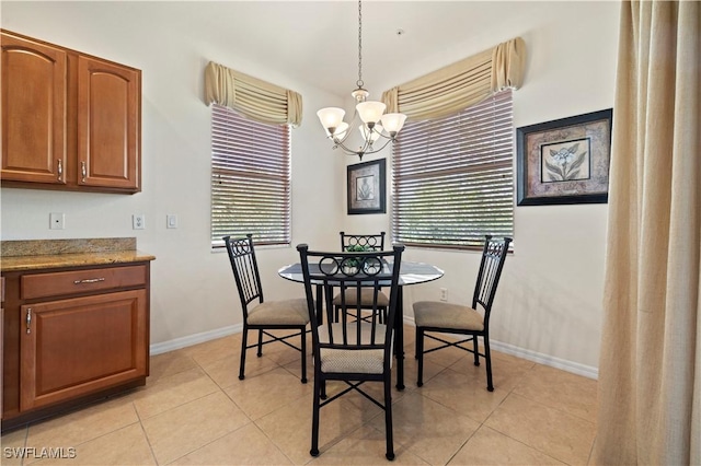 dining area featuring plenty of natural light, baseboards, light tile patterned floors, and a notable chandelier