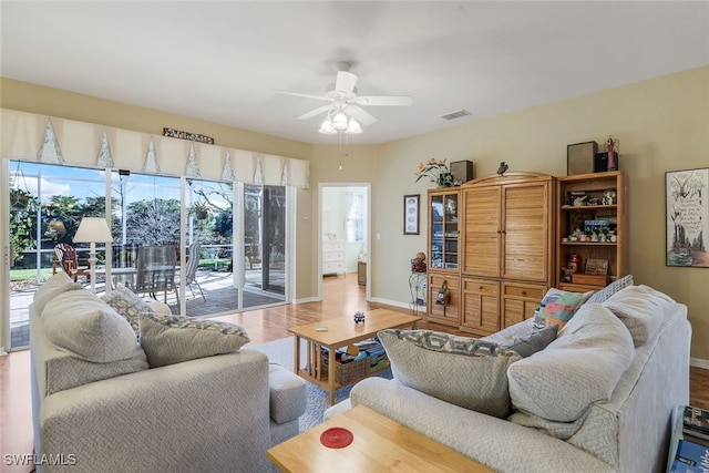 living room featuring baseboards, a ceiling fan, wood finished floors, and visible vents