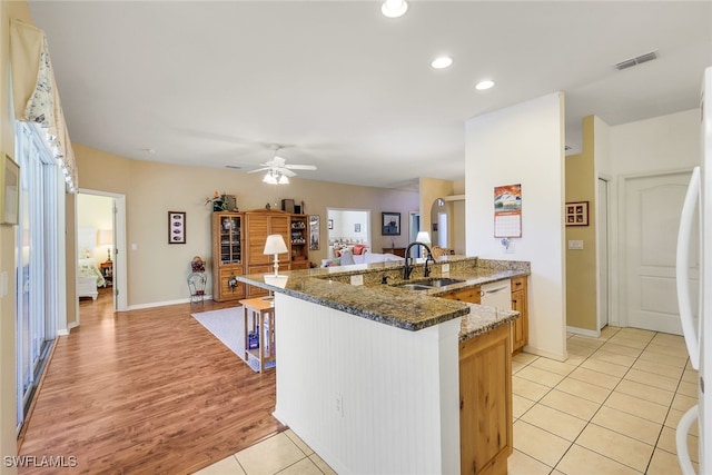 kitchen with ceiling fan, a sink, dark stone countertops, recessed lighting, and white appliances