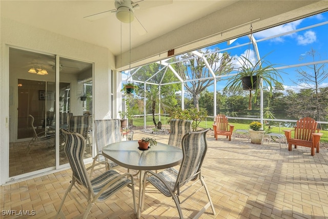sunroom / solarium with a ceiling fan and outdoor dining area