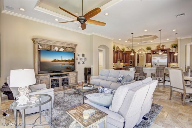 living room featuring visible vents, recessed lighting, a raised ceiling, arched walkways, and ceiling fan with notable chandelier