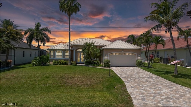 2536 SW 28th Pl, Cape Coral, FL 33914 - view of front of home featuring a standing seam roof, driveway, a front yard, an attached garage, and stucco siding