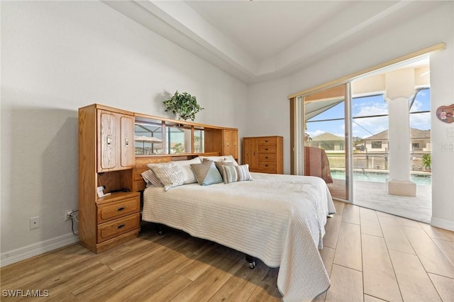 2536 SW 28th Pl, Cape Coral, FL 33914 - bedroom with baseboards, access to exterior, light wood-style flooring, and a towering ceiling