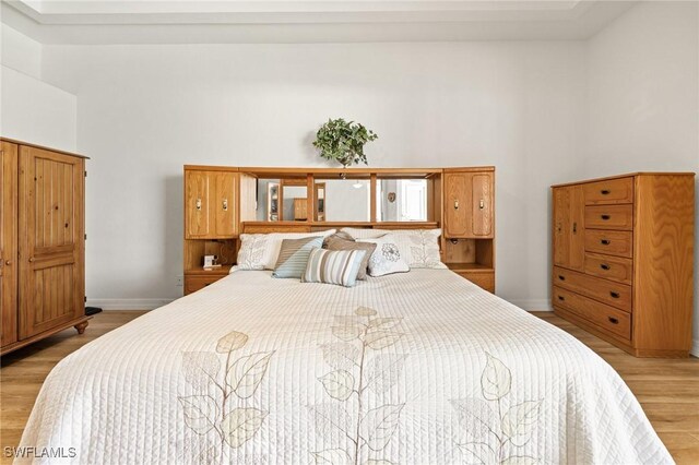 2536 SW 28th Pl, Cape Coral, FL 33914 - bedroom featuring baseboards, light wood-type flooring, and a towering ceiling