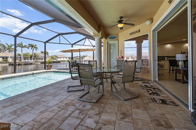 2536 SW 28th Pl, Cape Coral, FL 33914 - view of patio with glass enclosure, a water view, a ceiling fan, and an outdoor pool