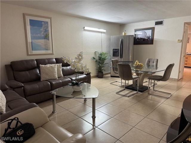 living room featuring baseboards, visible vents, and light tile patterned floors