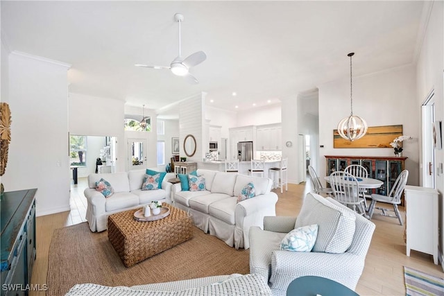 living area featuring ceiling fan, a chandelier, light wood-style flooring, crown molding, and recessed lighting