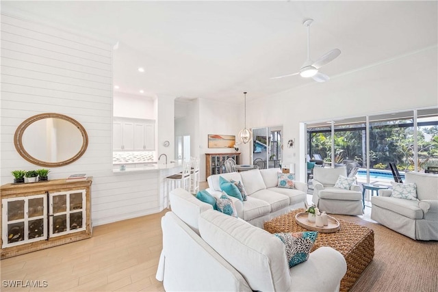 living room featuring ceiling fan, light wood-style flooring, and recessed lighting