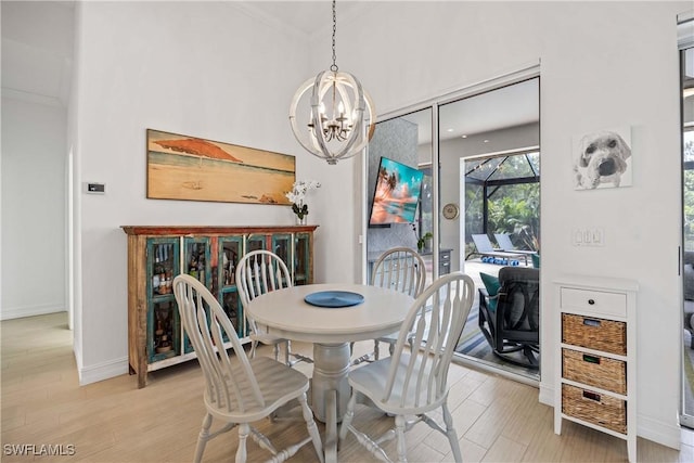 dining area featuring a chandelier, light wood-style flooring, and baseboards