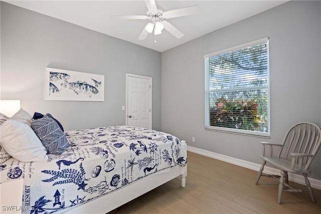 bedroom featuring wood finished floors, baseboards, and ceiling fan