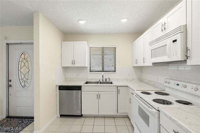7136 Blanquilla Ct, Fort Myers, FL 33908 - kitchen featuring white appliances, a sink, white cabinets, backsplash, and a textured ceiling