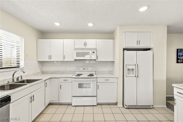 7136 Blanquilla Ct, Fort Myers, FL 33908 - kitchen with white appliances, a sink, white cabinetry, a textured ceiling, and light countertops