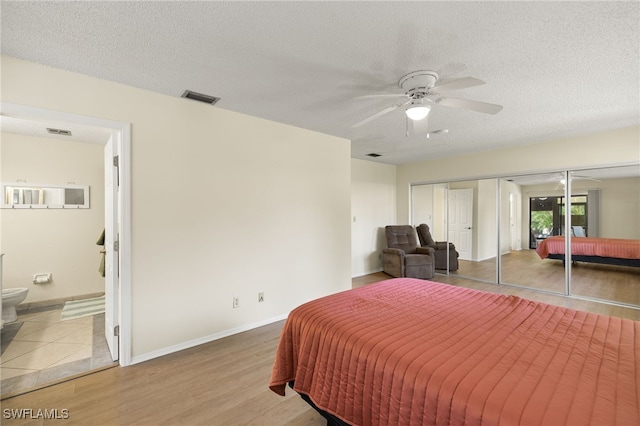 7136 Blanquilla Ct, Fort Myers, FL 33908 - bedroom featuring baseboards, ensuite bath, wood finished floors, a textured ceiling, and a ceiling fan