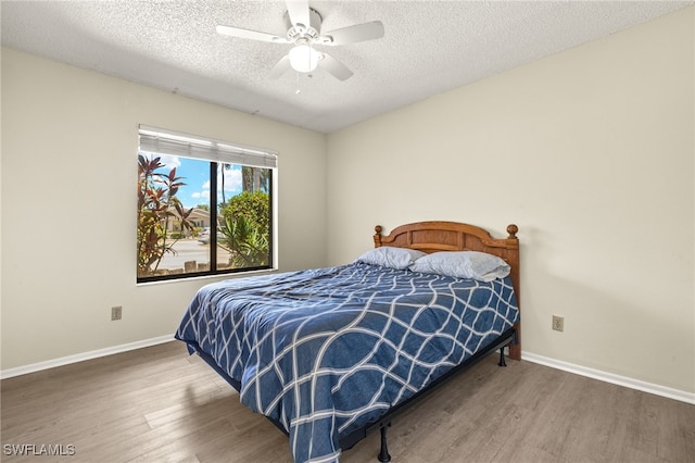 7136 Blanquilla Ct, Fort Myers, FL 33908 - bedroom featuring wood finished floors, a textured ceiling, baseboards, and a ceiling fan