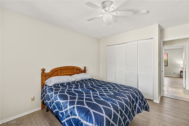 7136 Blanquilla Ct, Fort Myers, FL 33908 - bedroom featuring light wood finished floors, a closet, baseboards, a textured ceiling, and a ceiling fan