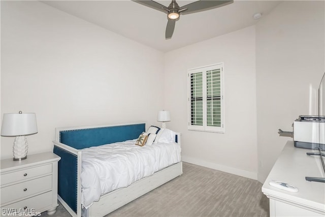 bedroom featuring baseboards, wood finished floors, and a ceiling fan
