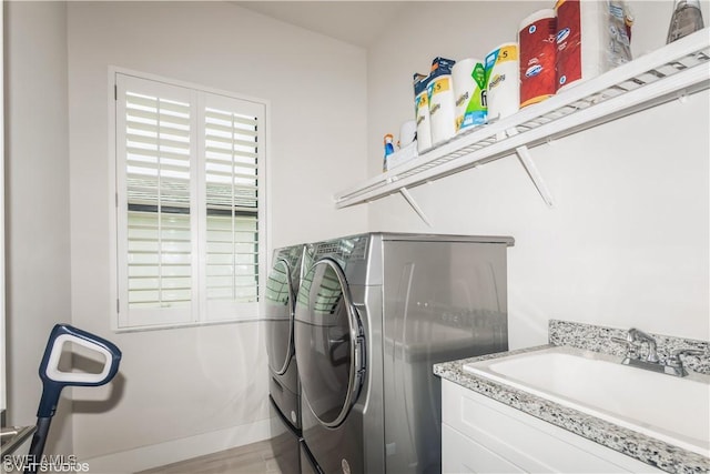 clothes washing area featuring washer and clothes dryer and baseboards