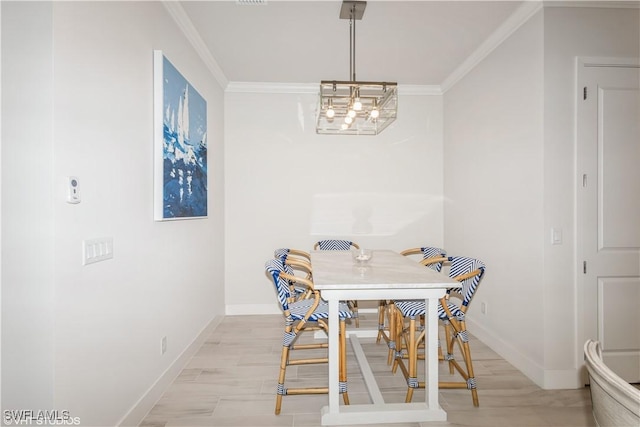 dining area featuring ornamental molding, baseboards, light wood-type flooring, and a chandelier