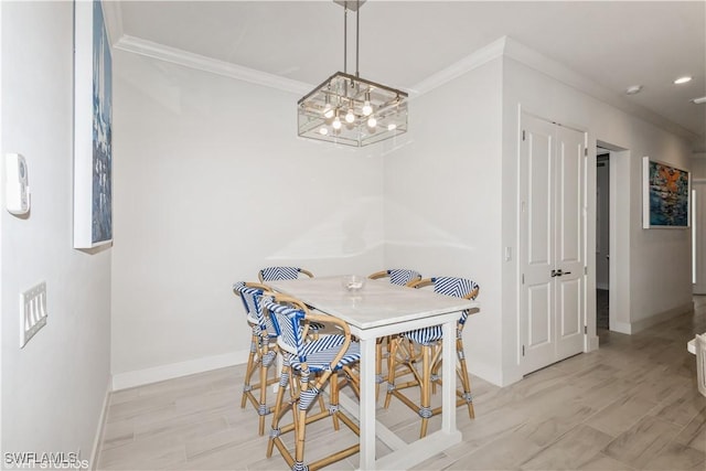 dining space with crown molding, baseboards, a chandelier, and light wood-type flooring