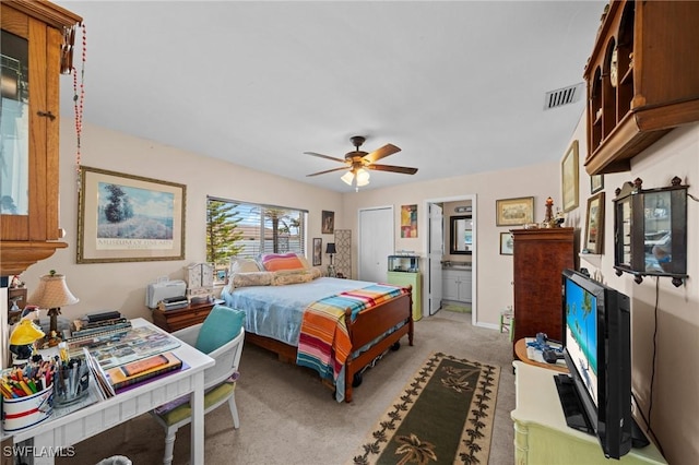 bedroom featuring light colored carpet, a ceiling fan, and ensuite bathroom