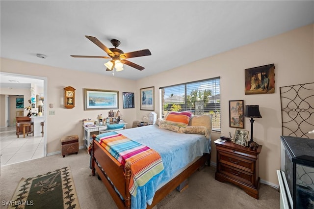 bedroom with light carpet, baseboards, and a ceiling fan
