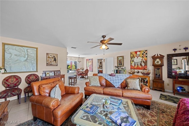 living room with light tile patterned floors, ceiling fan, and baseboards