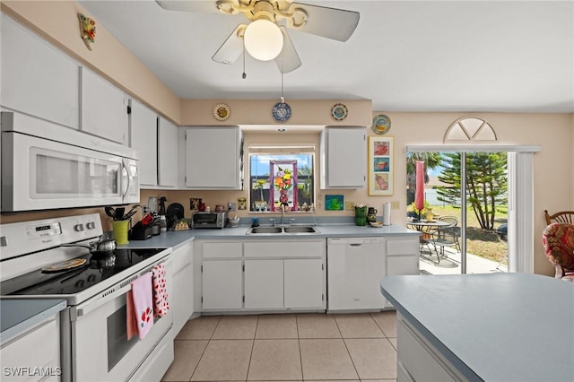 kitchen featuring white appliances, a sink, light countertops, and light tile patterned floors