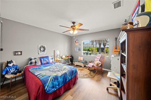 bedroom featuring wood finished floors, baseboards, and a ceiling fan