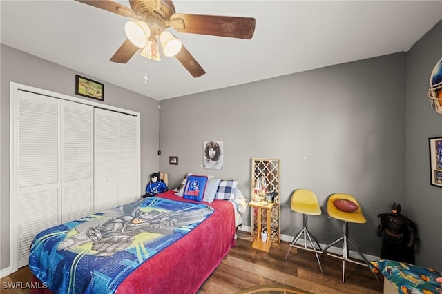 bedroom with wood finished floors, a closet, ceiling fan, and baseboards