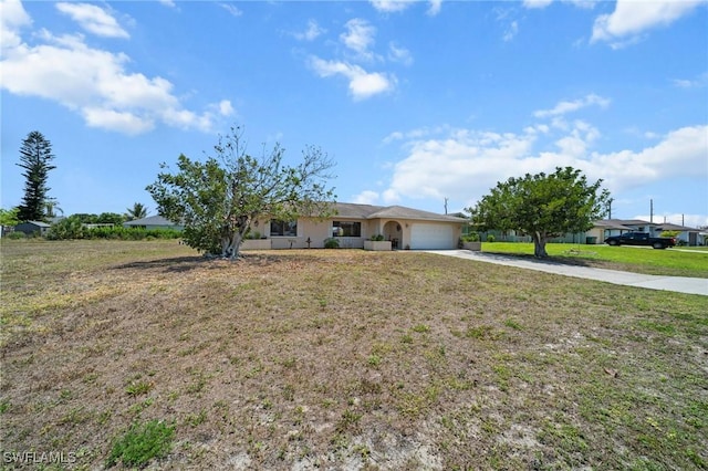ranch-style house featuring driveway, an attached garage, and a front yard