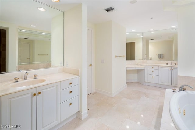 bathroom with a garden tub, visible vents, two vanities, and a sink