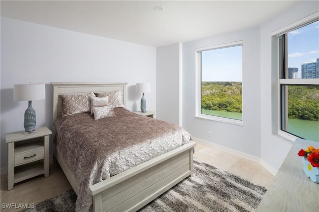 bedroom with light tile patterned flooring and baseboards