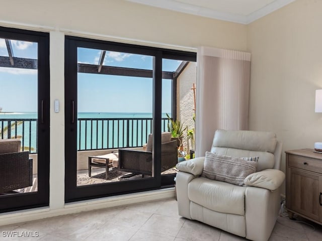 living area featuring crown molding, a water view, plenty of natural light, and light tile patterned floors