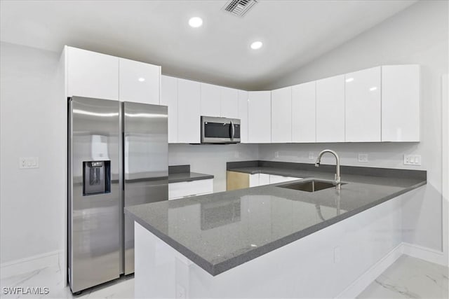 631 Summit Ave S, Lehigh Acres, FL 33974 - kitchen with appliances with stainless steel finishes, a sink, light marble finish flooring, a peninsula, and dark stone countertops